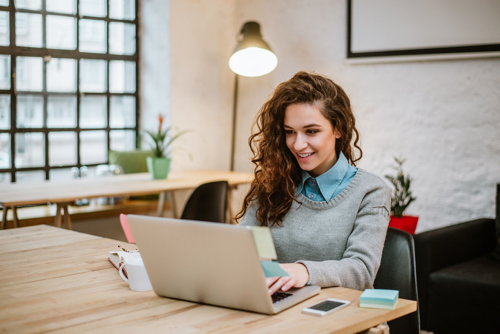 Smiling young woman using a laptop.