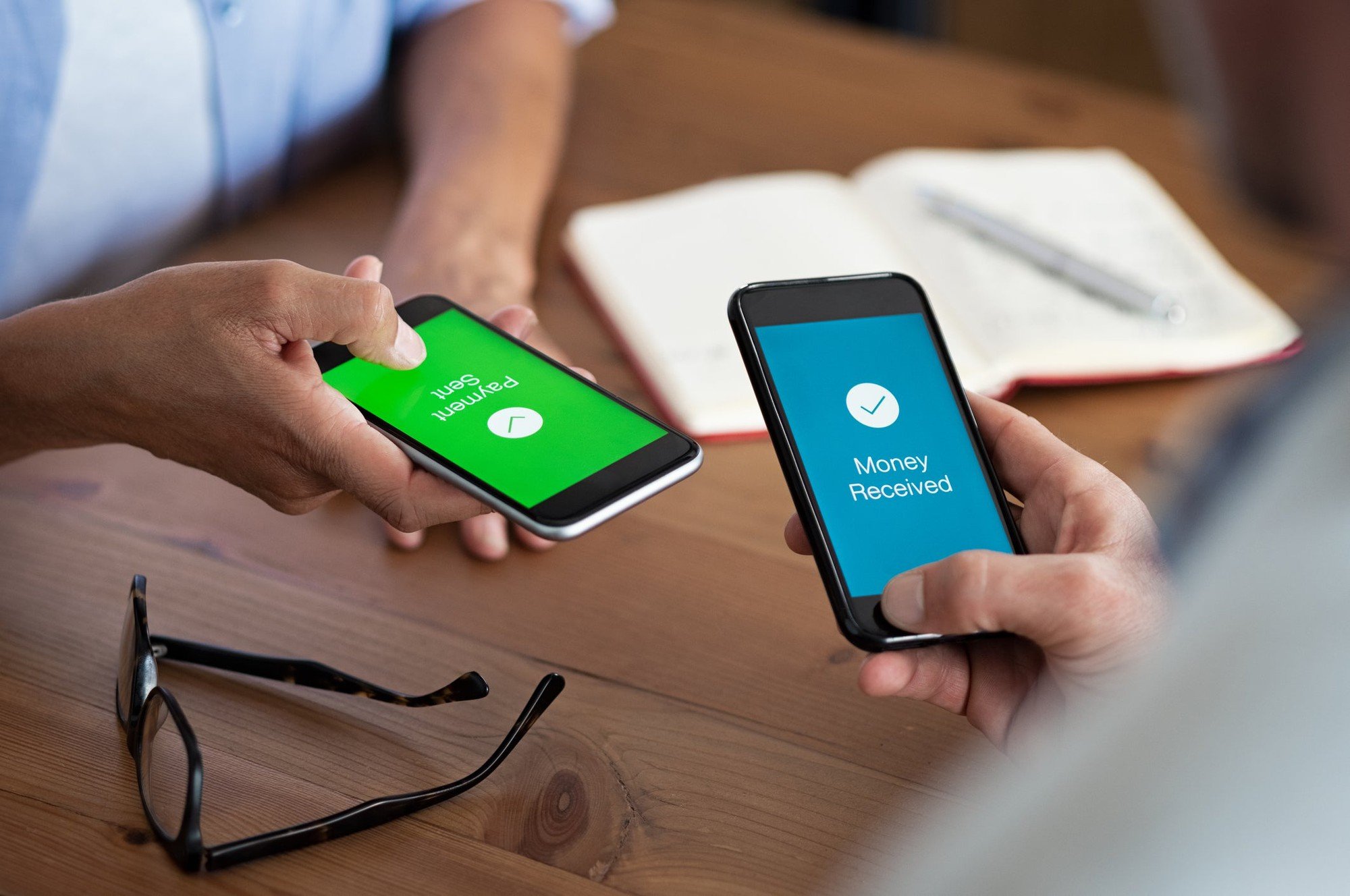 two_people_completing_transaction_wth_phones