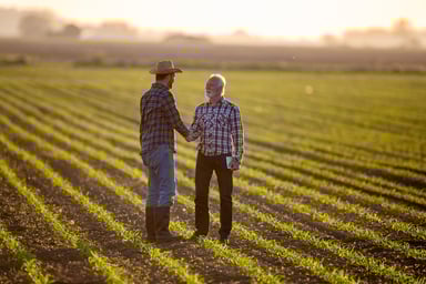 two_people_shaking_hands_in_a_field