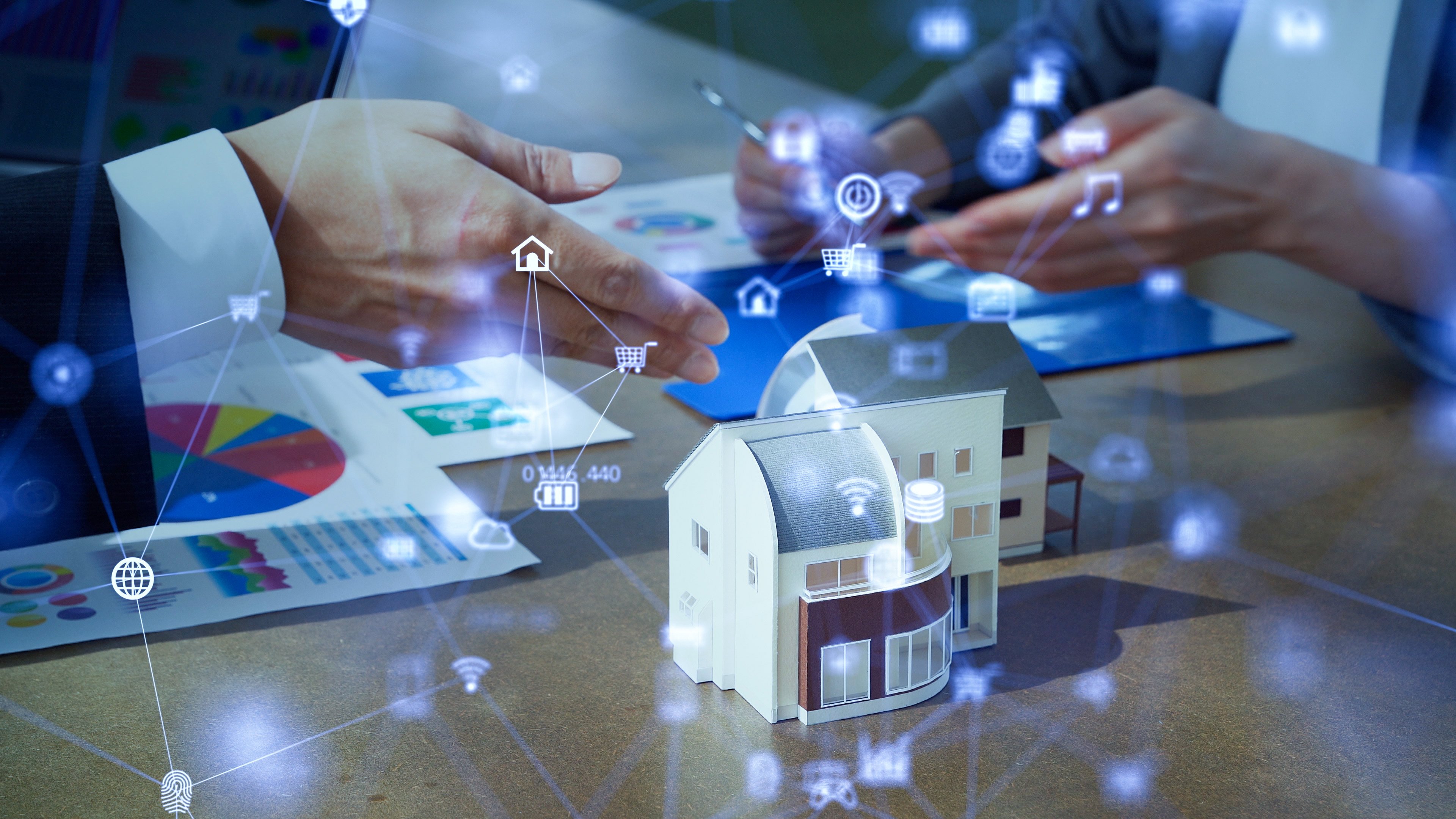 Image of model home on a desk with visual representation of smart home automations.