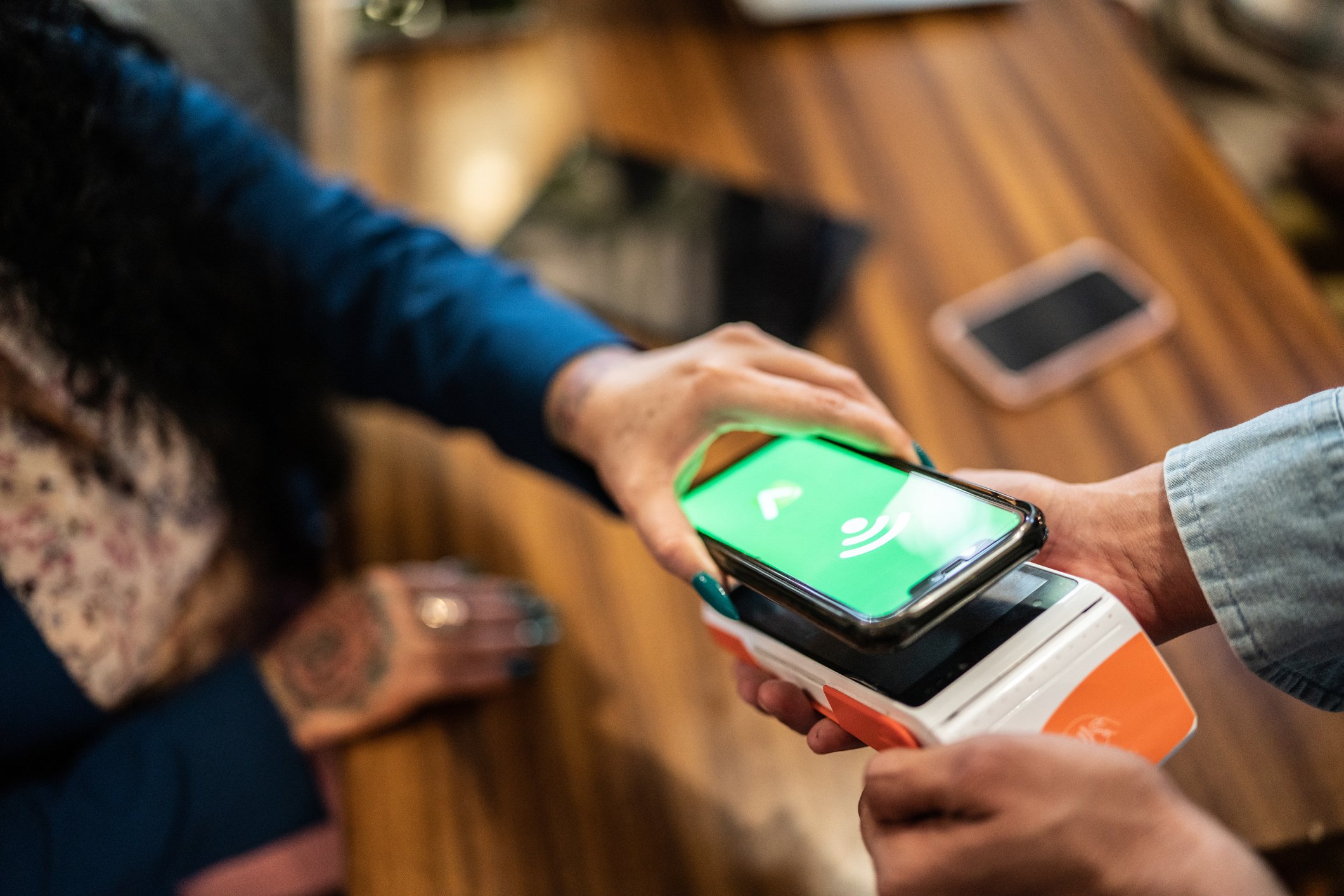 person paying with smartphone in restaurant