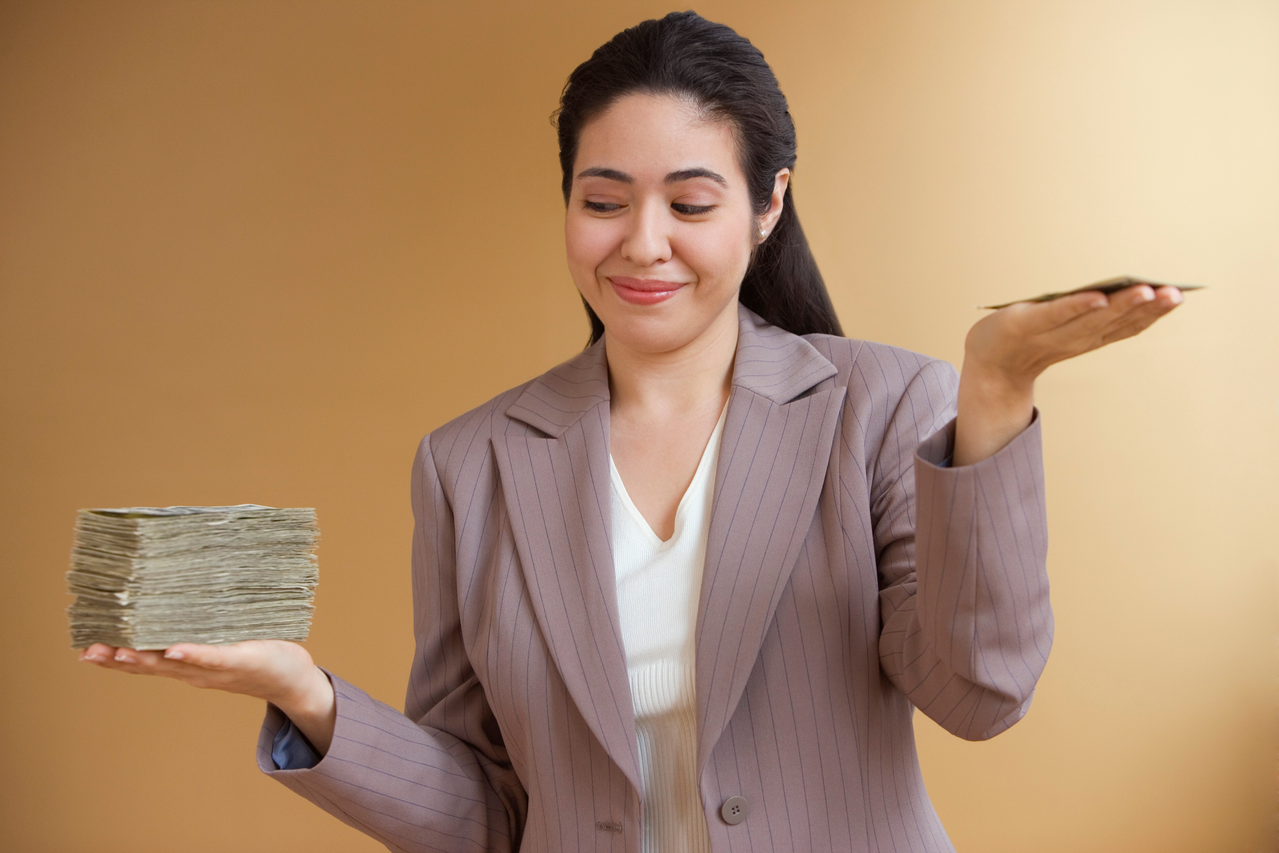 GettyImages-Woman choosing between large pile of cash in one hand and small pile in the other-57012424-1280x853-757a5e6.png