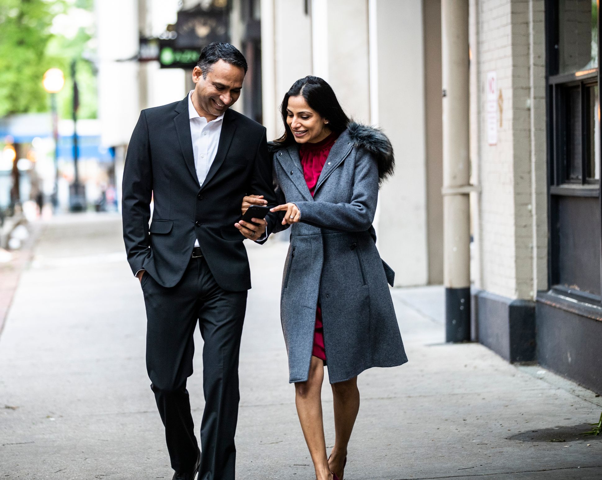 A couple walking and looking at a cell phone Getty Images.jpg