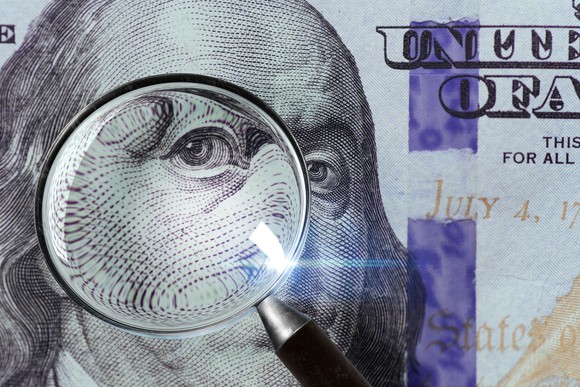 A 100 U.S. bill under a magnifying glass