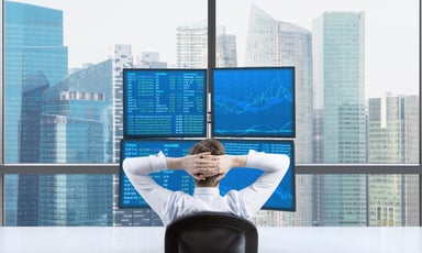Investor looking at charts and data overlookin a skyline -- GettyImages-498400234