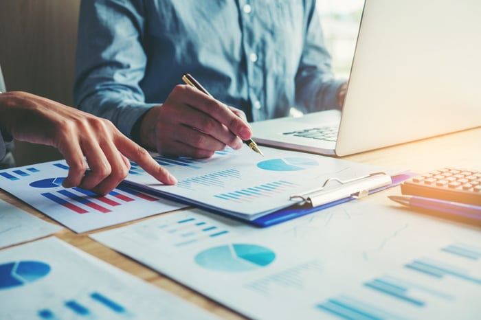 Hands of businesspeople pointing out parts of charts