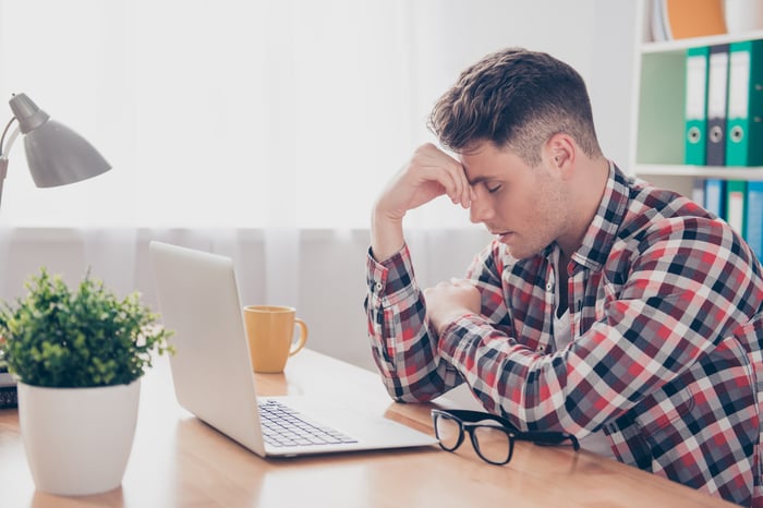 Man holding his head, bemoaning his poor tax planning.