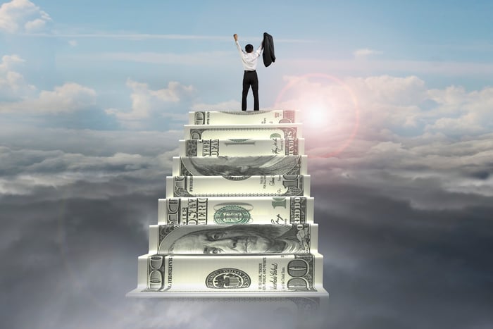 man at top of stairway made of money in the sky