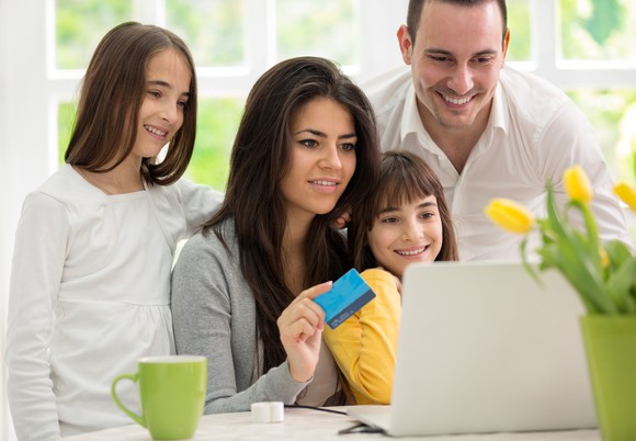 A happy family around a laptop, engaging in e-commerce