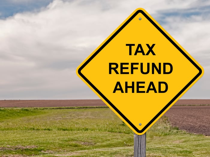 Yellow road sign that says tax refund ahead