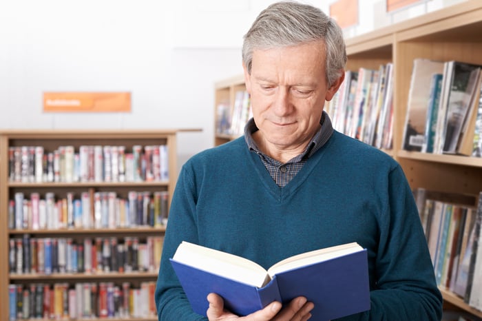 Senior man reading in a library