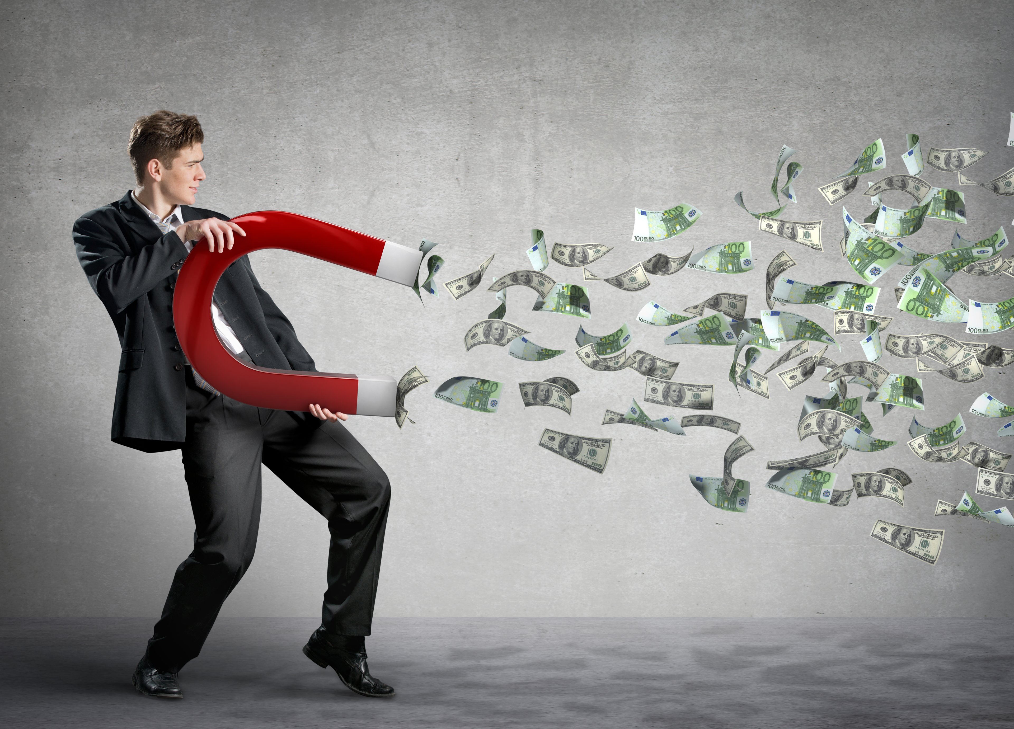 Dividend Income Business man with giant magnent attracting money