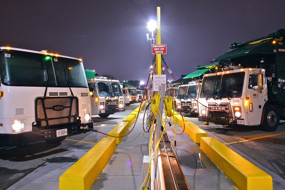 Fleet of Waste Management garbage trucks refueling.