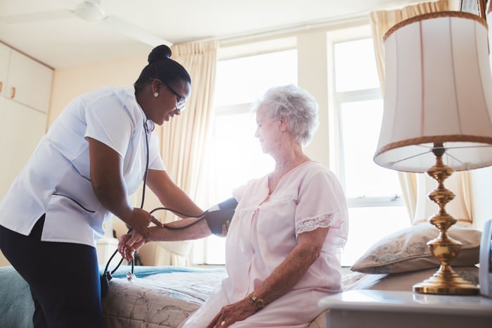 Nurse checking elderly patient's blood pressure