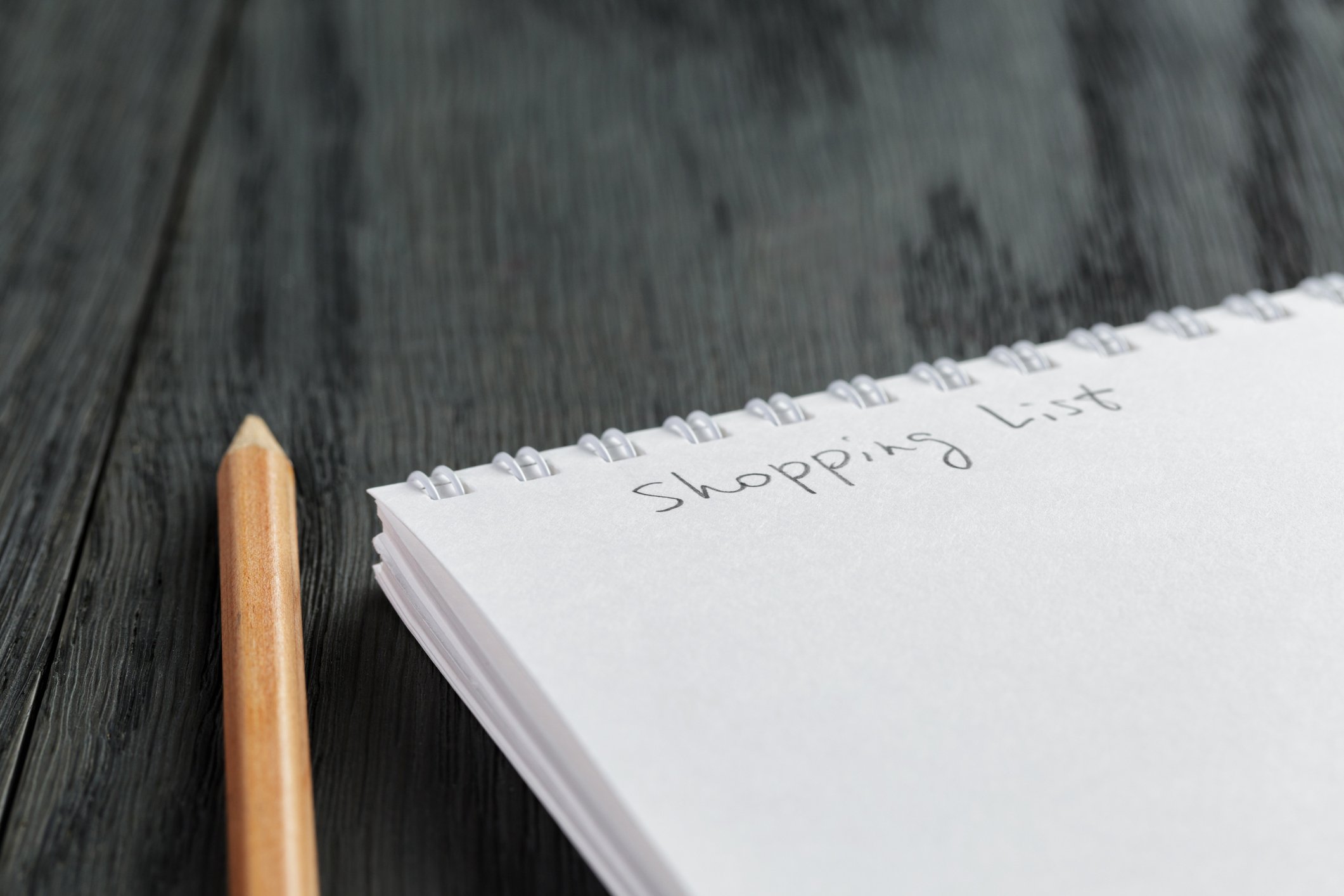 closeup photo of open empty notepad with shopping list phrase
