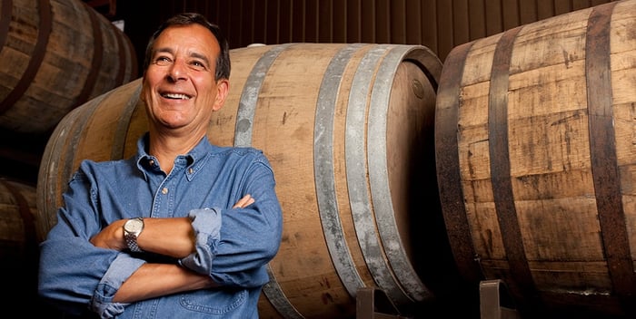 Boston Beer founder Jim Koch standing in front of barrels