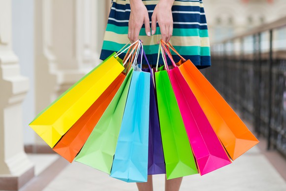 A woman holding colorful shopping bags.