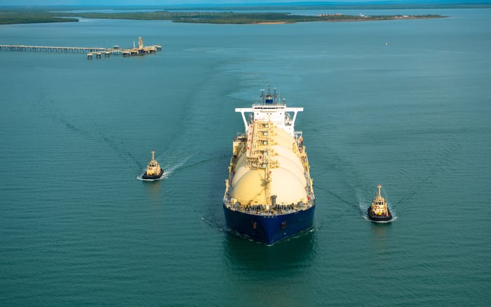 Fully loaded liquid natural gas tanker departing a harbor.