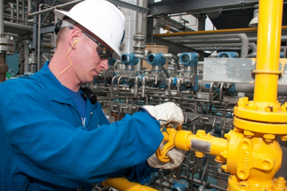 An Enterprise Products Partners employee turning a yellow valve.