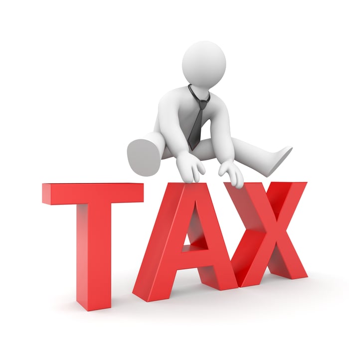 Drawn figure of person leaping over the word tax