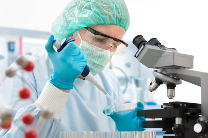 Woman scientist examining a test under a microscope