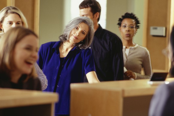 A woman looking disappointed while waiting in line at a bank.