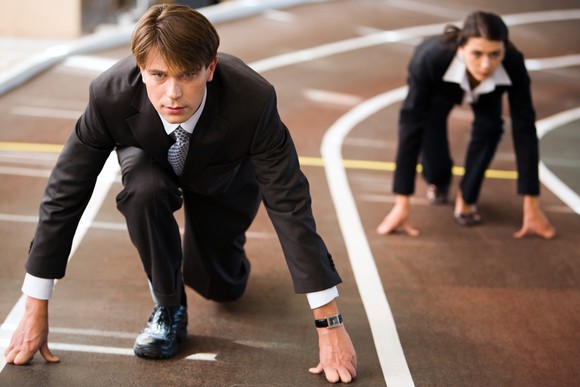Two businesspeople at the starting line of a track competition.