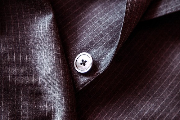 close up of detail of suit, featuring button