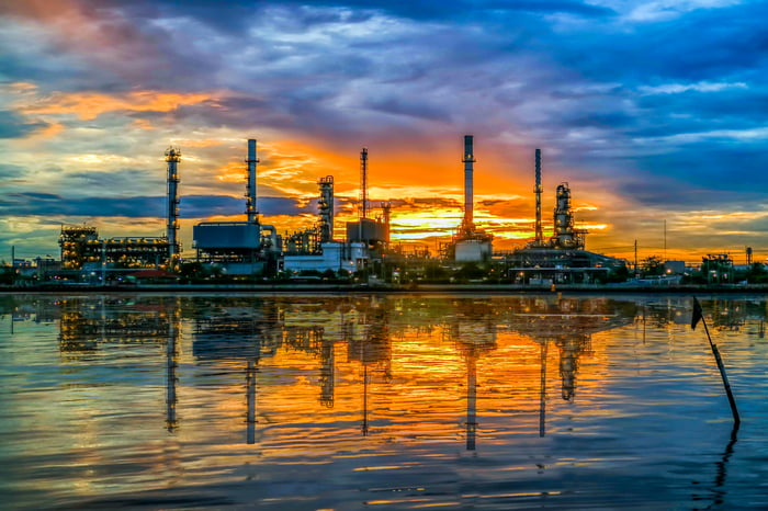 An oil refinery at twilight reflected in the water.