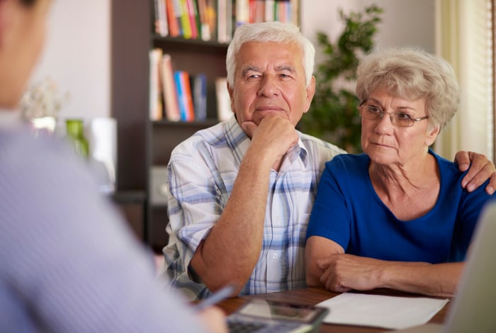 Senior couple looking serious while talking to a financial advisor