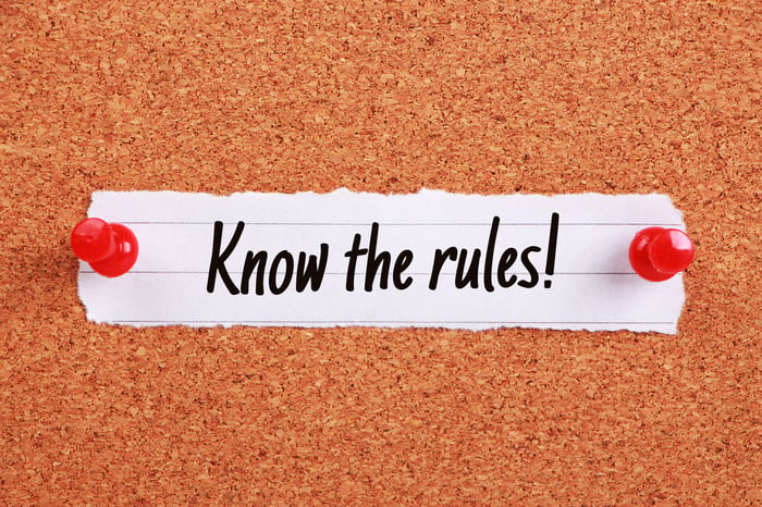 Little piece of paper pinned to corkboard. It says "know the rules!"