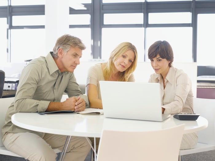 Couple looking at computer with financial advisor