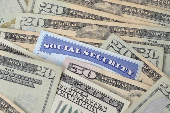 A Social Security card nestled among dollar bills