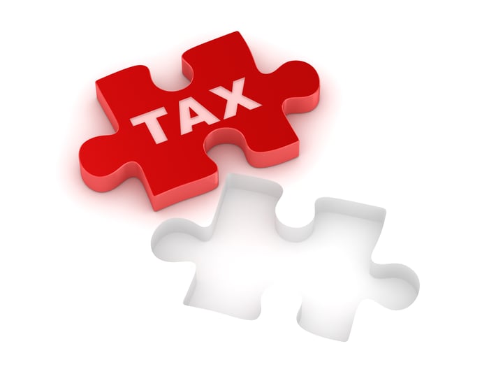 Red jigsaw piece on which is written "tax," fitting into its space