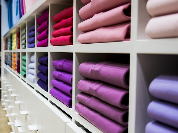 Piles of neatly folded shirts on display at retailer