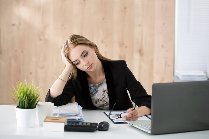 Bored woman in business attire at her desk