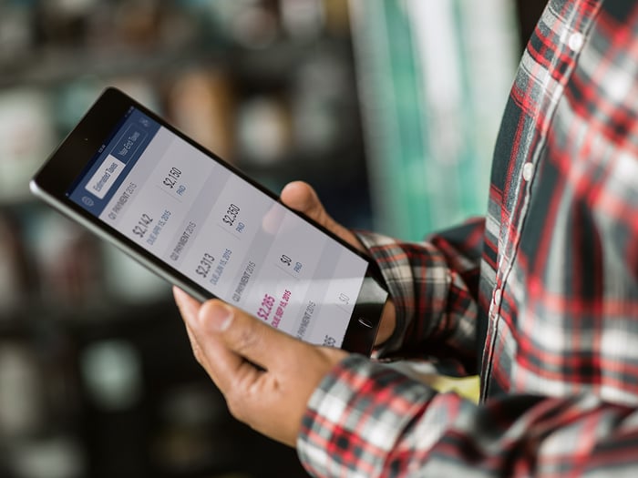 A man uses QuickBooks on a tablet.