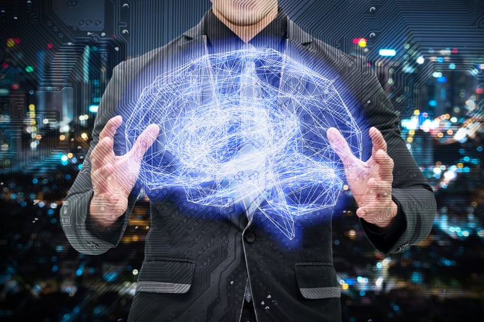 Man in a suit holding a holographic image of a brain