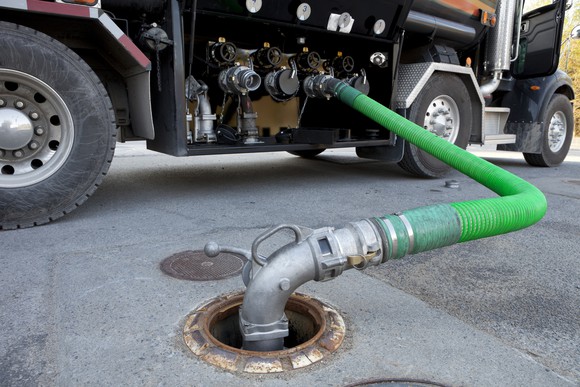 Fuel tanker truck delivering gasoline to a gas station.