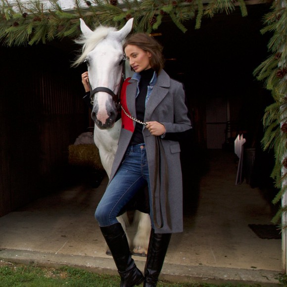 A woman poses with a horse.
