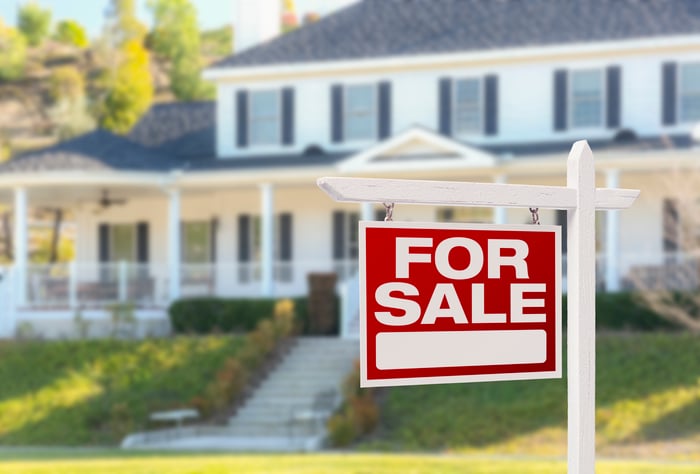 Home with a "for sale" sign on the lawn