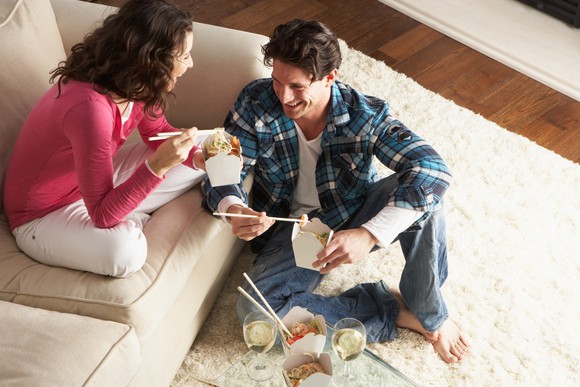 Couple eating takeout at home