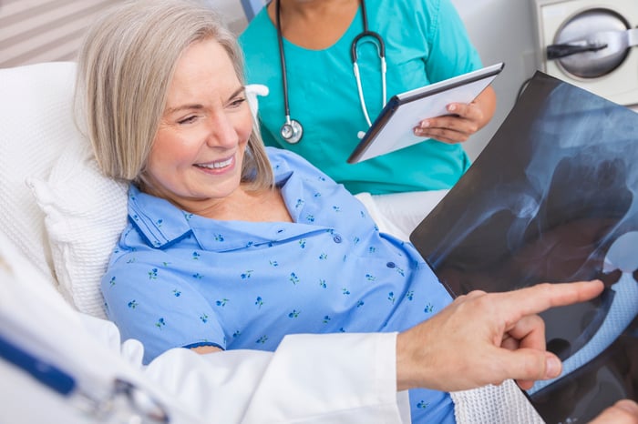 A doctor speaking with a patient about her hip X-rays.