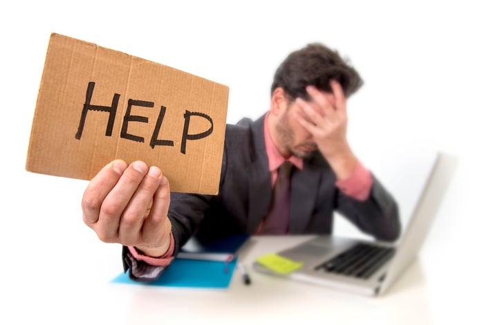 Employee holding up "help" sign