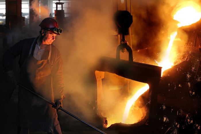 Steel worker in a foundry with molten steel flowing