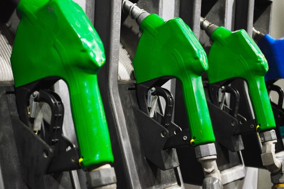 Green and blue fuel nozzles resting in a fuel pump bay