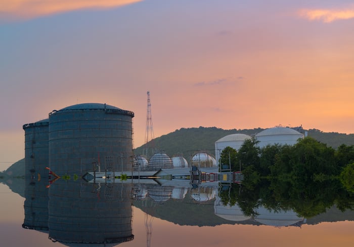 Natural gas liquids storage tanks reflecting on the water.