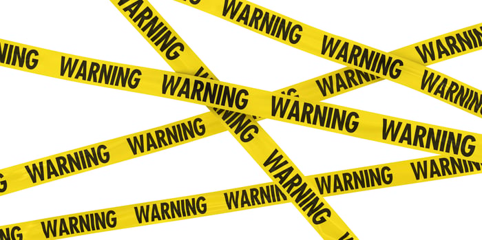 Yellow tape criss-crossing the image boarder, with "warning" printed repeatedly on it