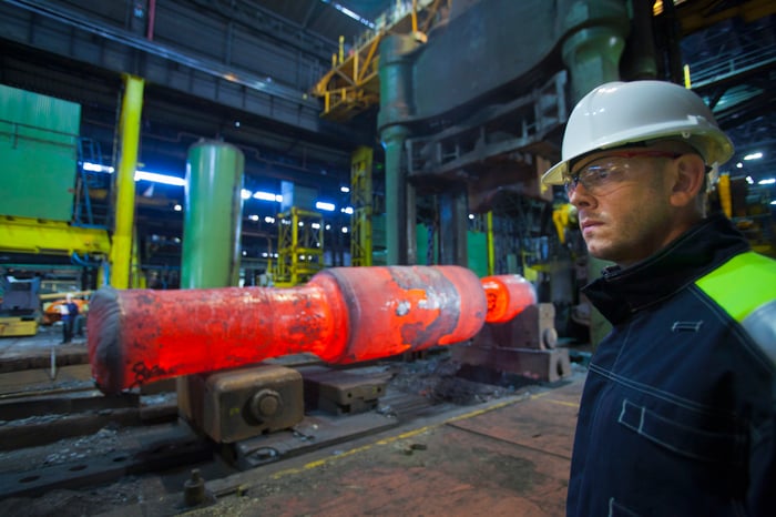 A worker standing in a steel forge