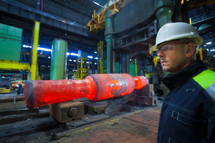 A worker standing in a steel forge 